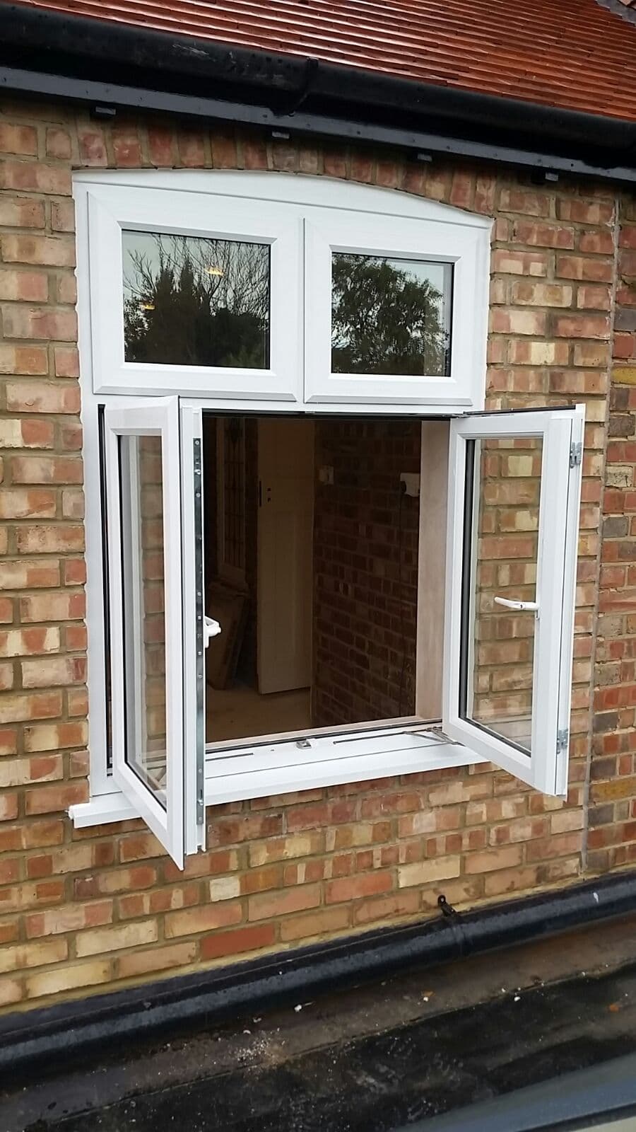 White uPVC casement window open on brick