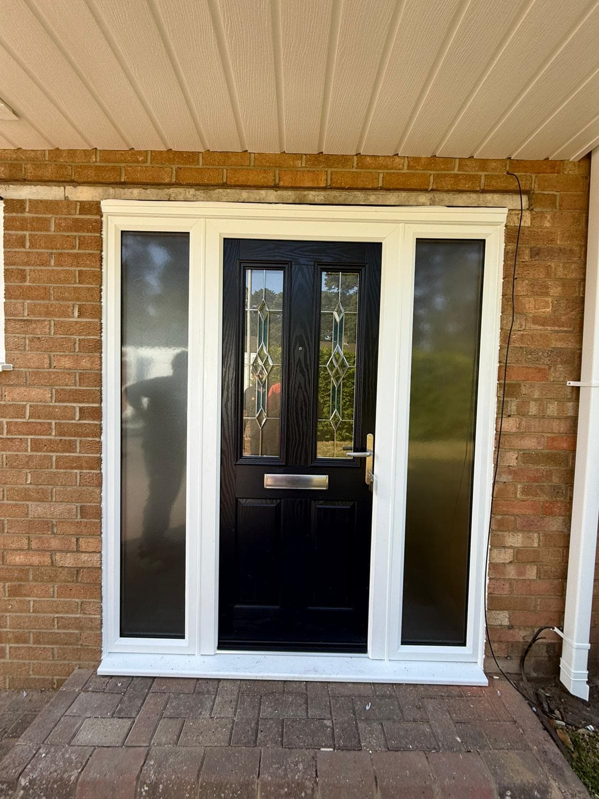 Black composite door with stained glass feature and sidelights