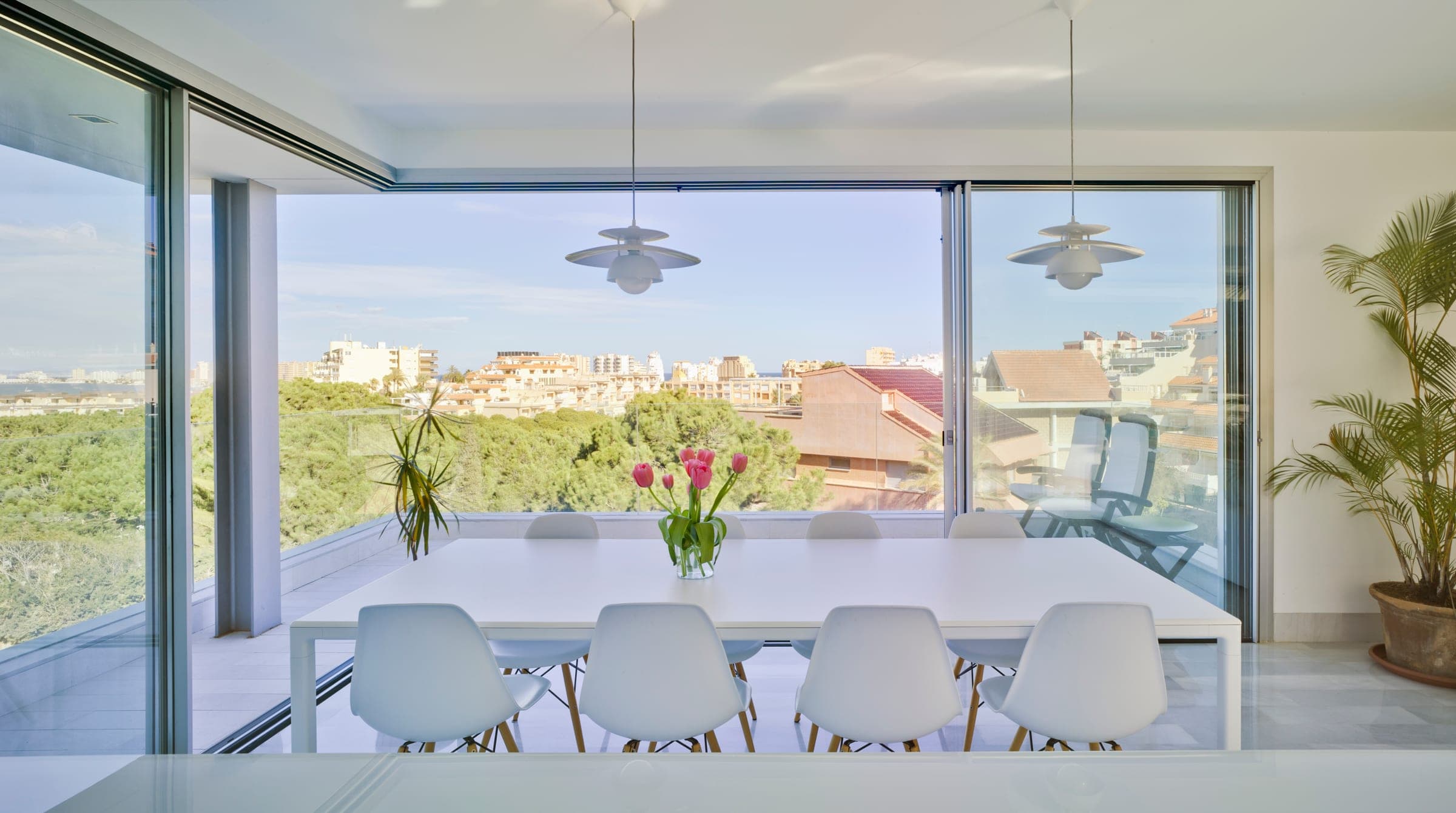 Cortizo sliding doors in a dining room with a panoramic view of the garden