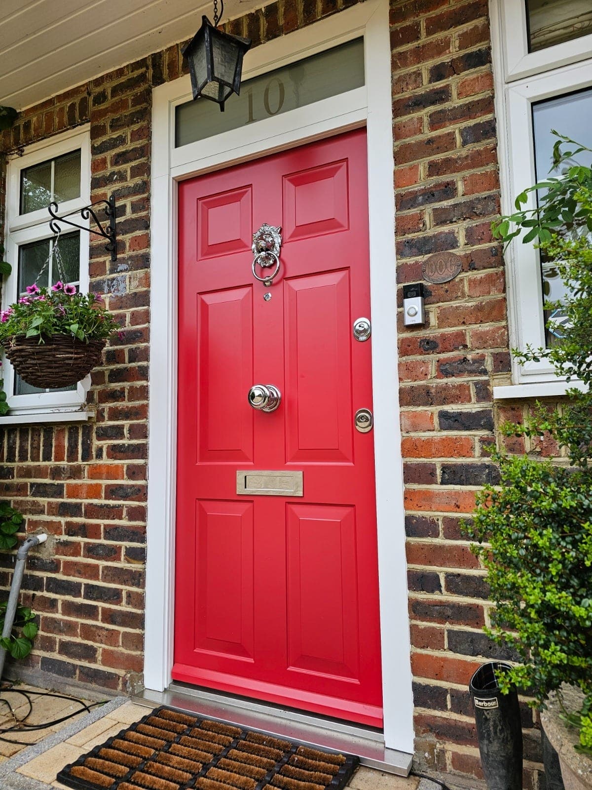 Classic red steel door with chrome lion knocker on period cottage