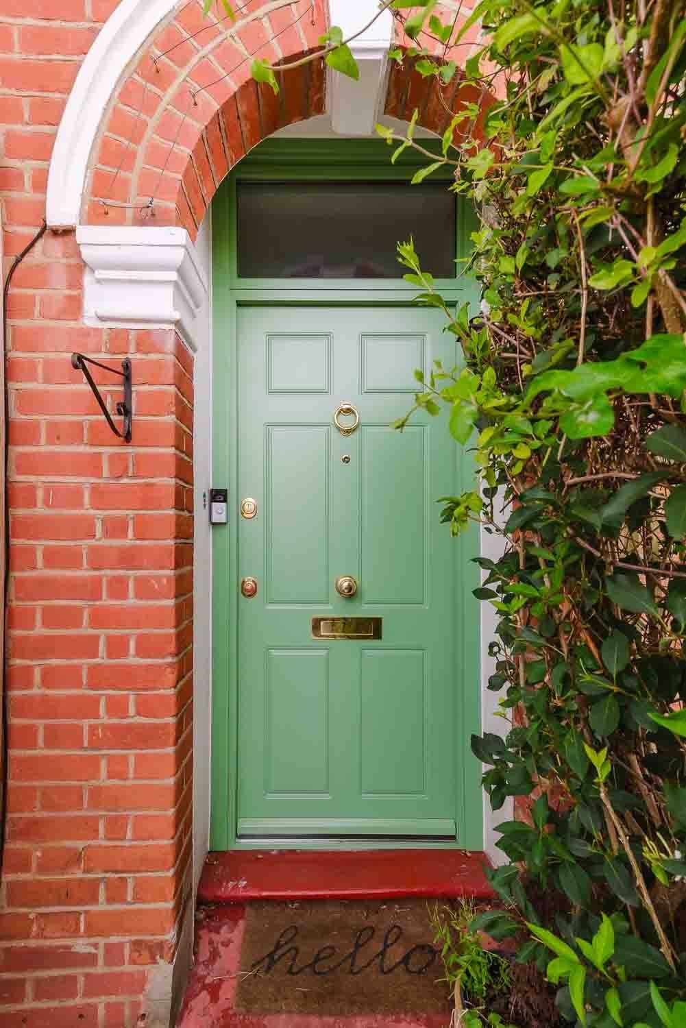 SteelR sage green traditional steel door with arched brick surround