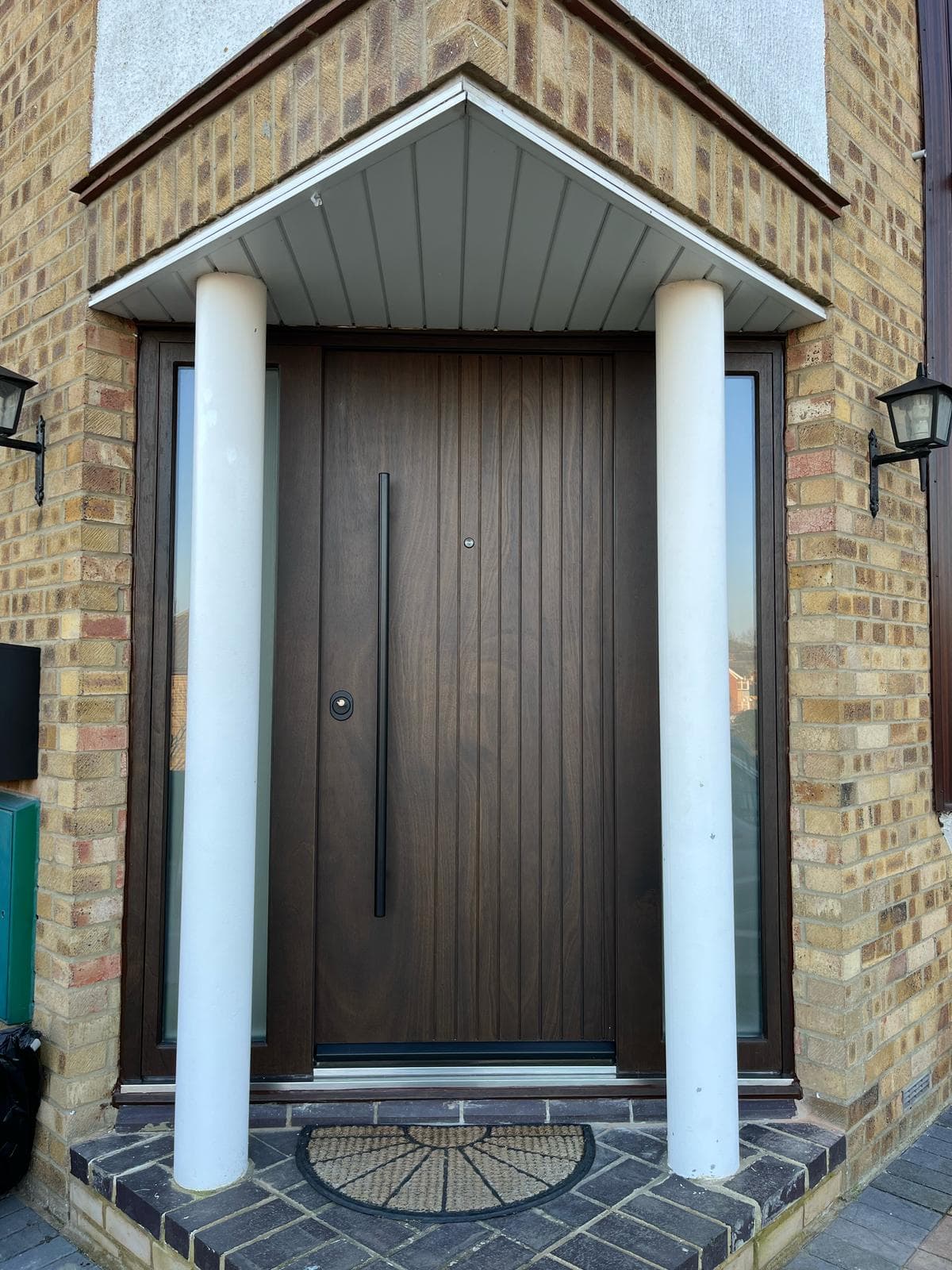 SteelR walnut finish steel door between ribbed stone columns