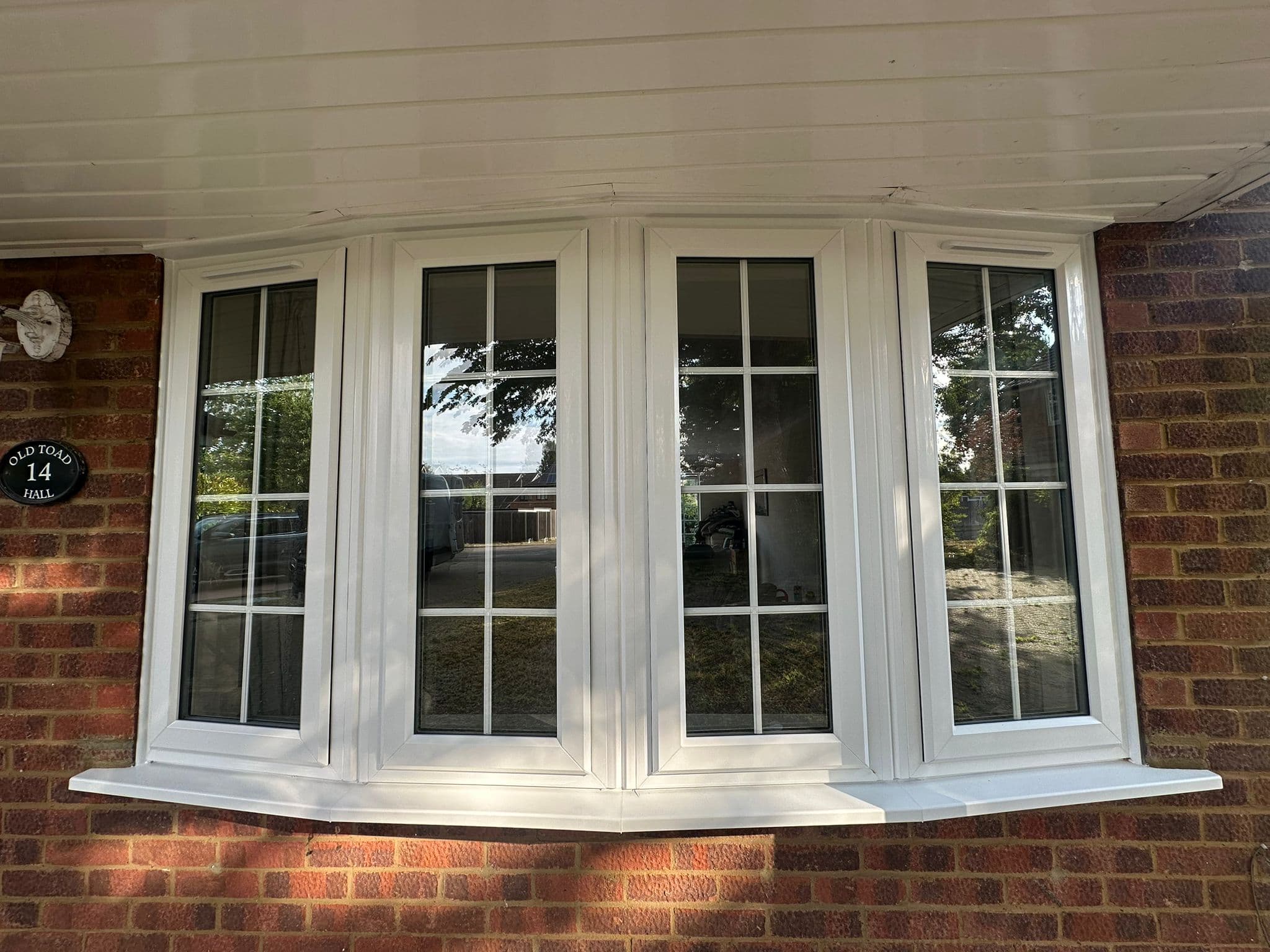 White uPVC bow window with Georgian bars on red brick home