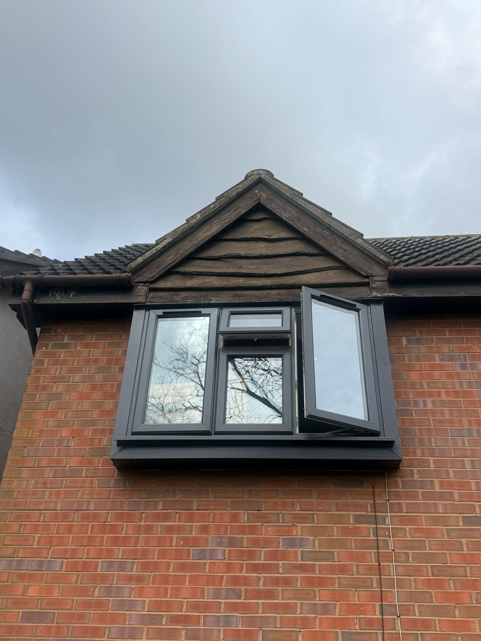 Anthracite uPVC casement dormer window open on a UK property with quiet interior