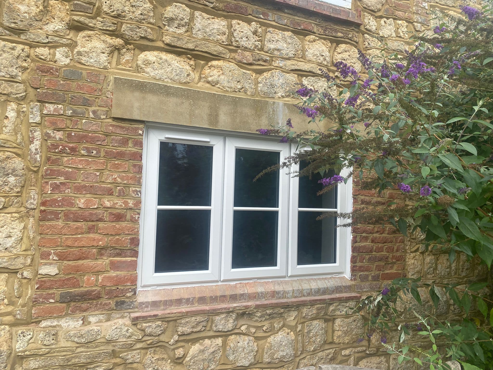 White uPVC casement windows fitted to a stone cottage showing traditional proportions and slim sightlines