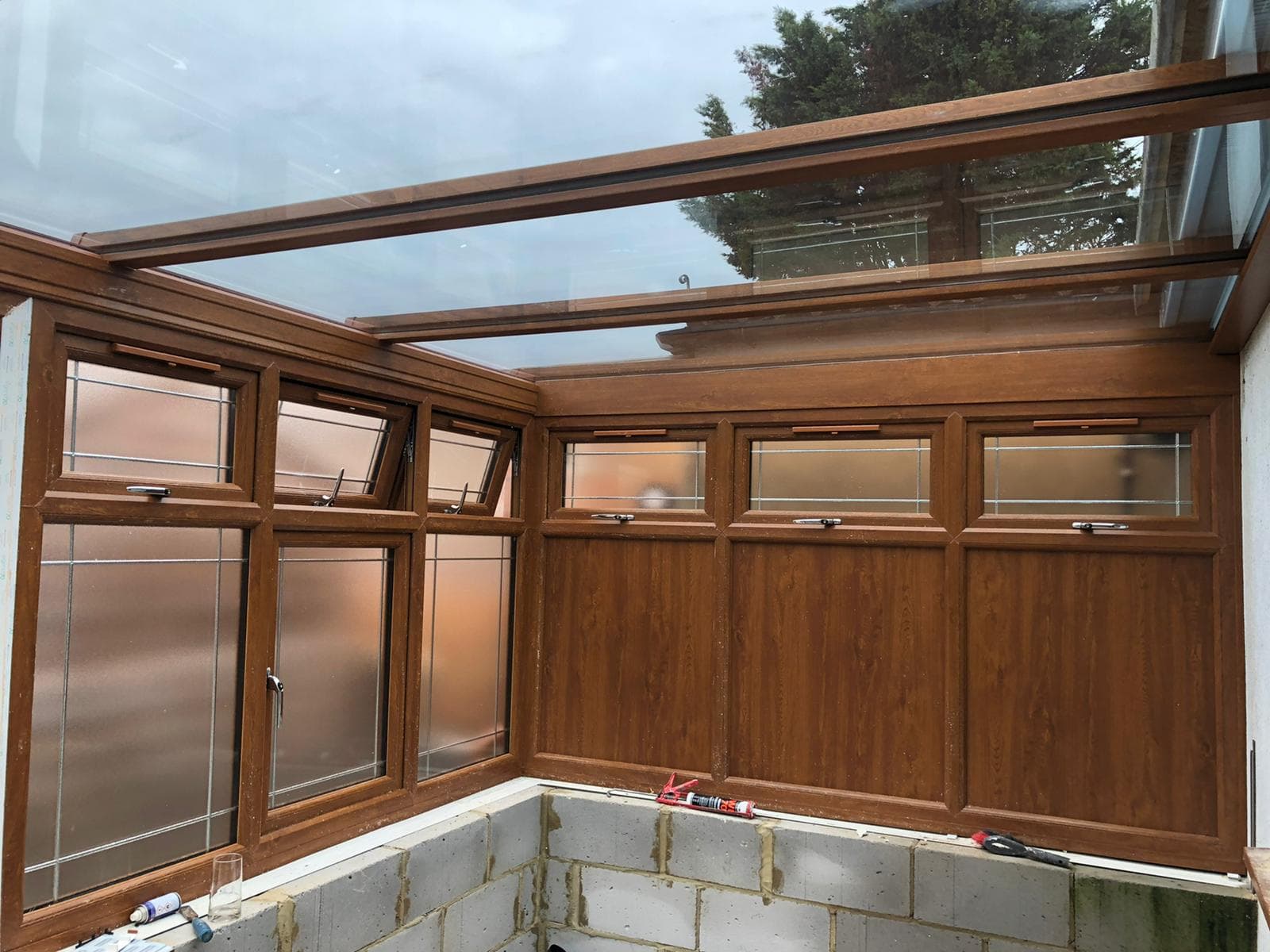 Oak woodgrain uPVC flush vent windows on conservatory style extension
