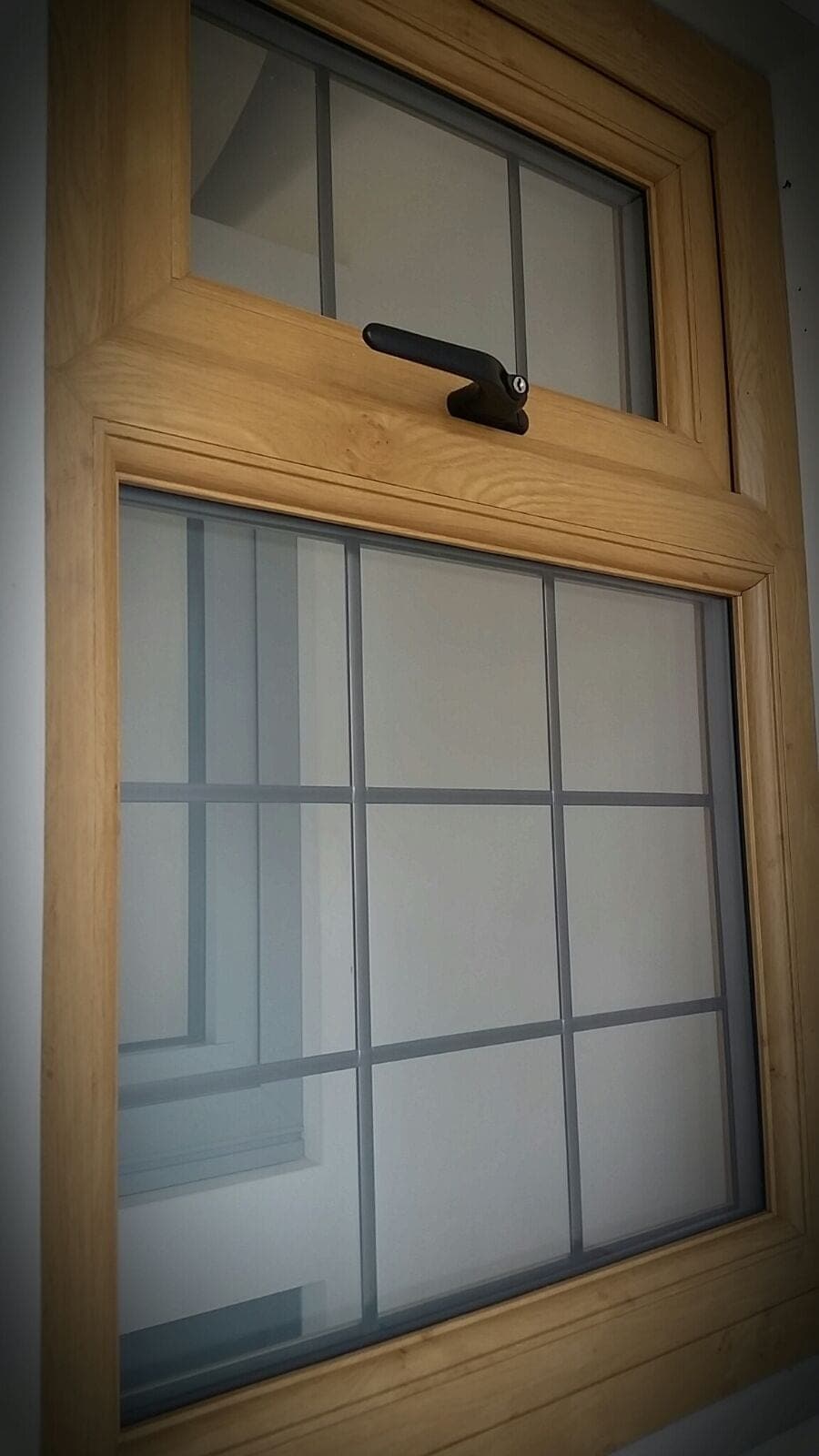 Oak finish uPVC sash window with Georgian bars close-up detail
