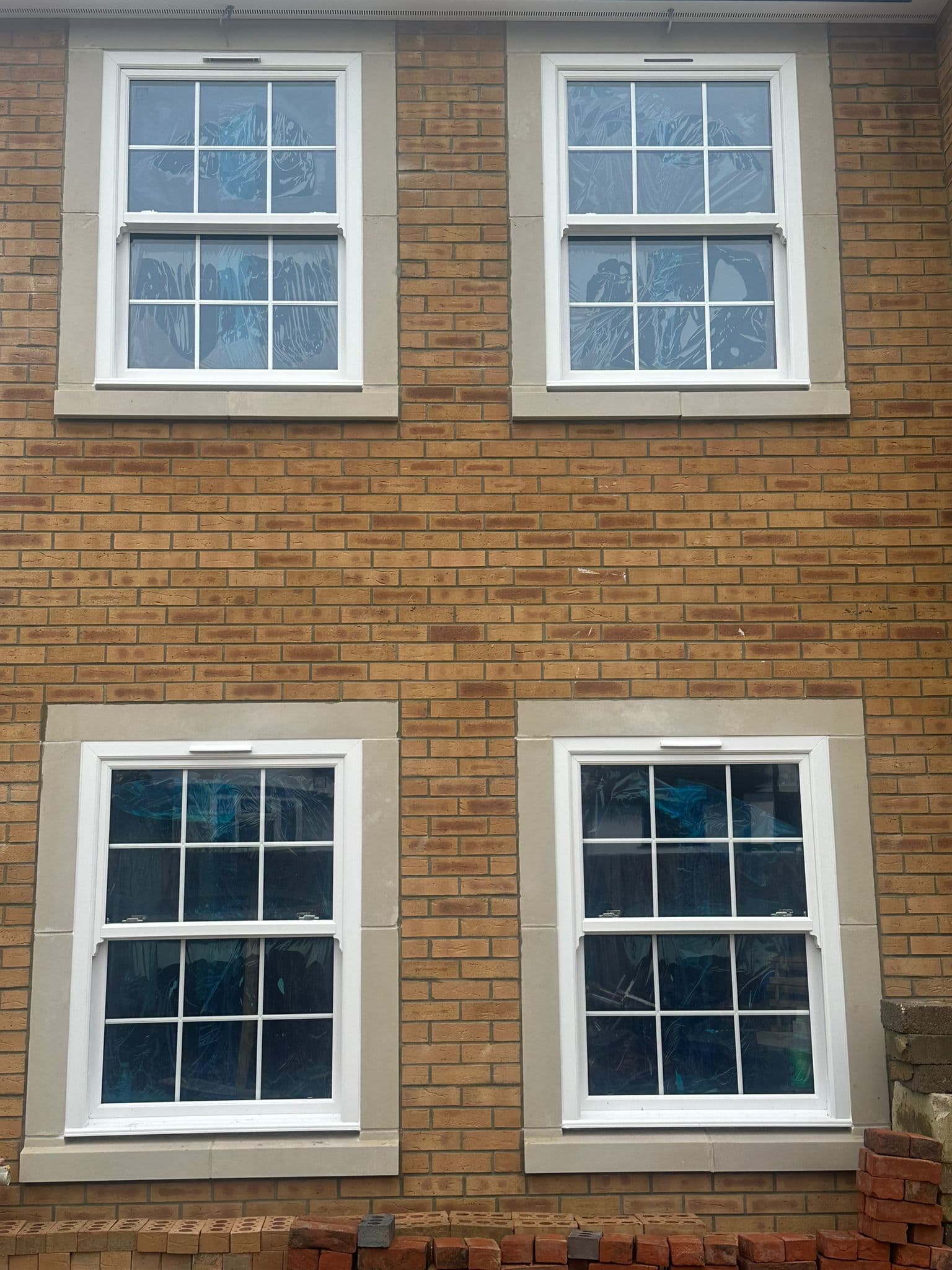 Georgian-style uPVC sliding sash windows on a period brick property in a UK conservation area