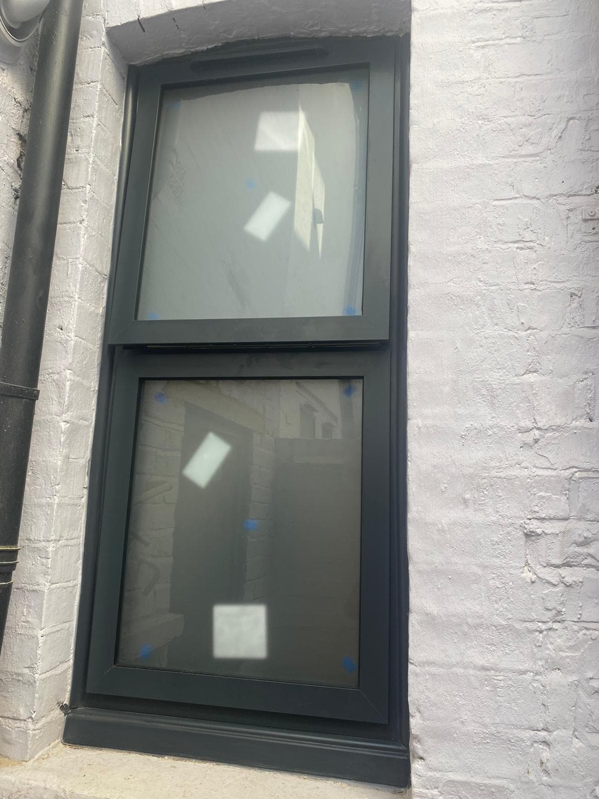 Anthracite Schuco-style aluminium casement windows installed on a modern UK brick home