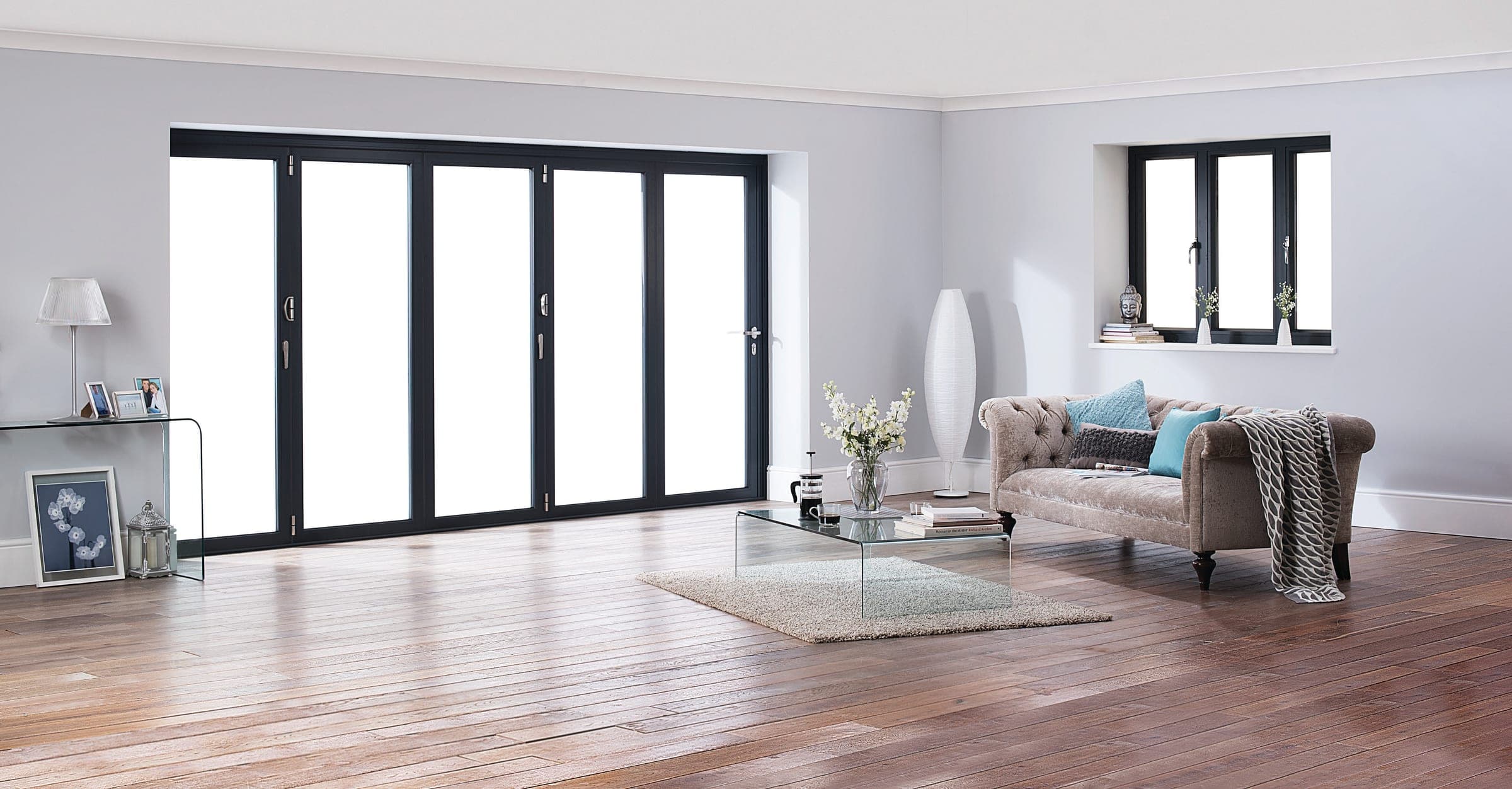 Origin OB-72 standard aluminium bifold doors open to a residential garden from a contemporary living room