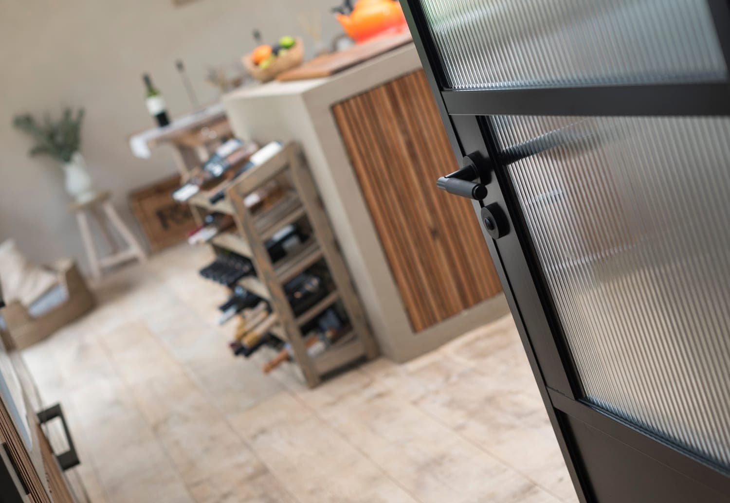 Origin OI-30 aluminium internal door framing a wide kitchen view with island and shelving in a contemporary UK home