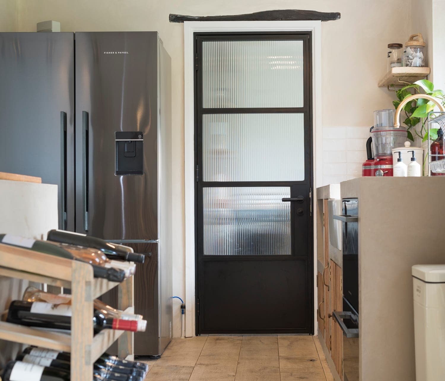 Origin OI-30 aluminium internal door in a utility room with washing machine and open shelving, showing the 30 mm slim sightline frame