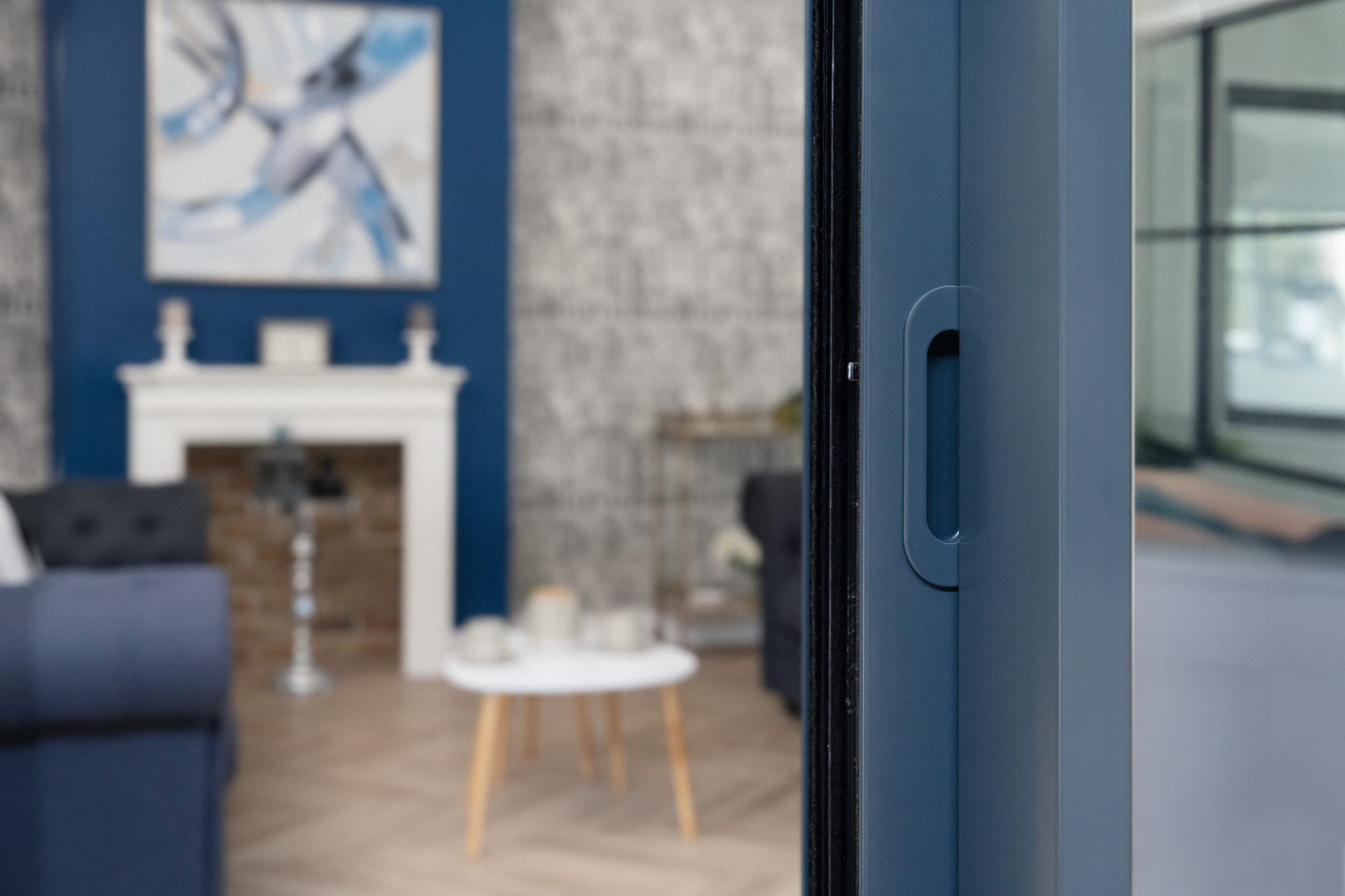 Origin OS-29+ ultra-slim aluminium sliding doors with flush-stacking in a contemporary blue-toned residential living room