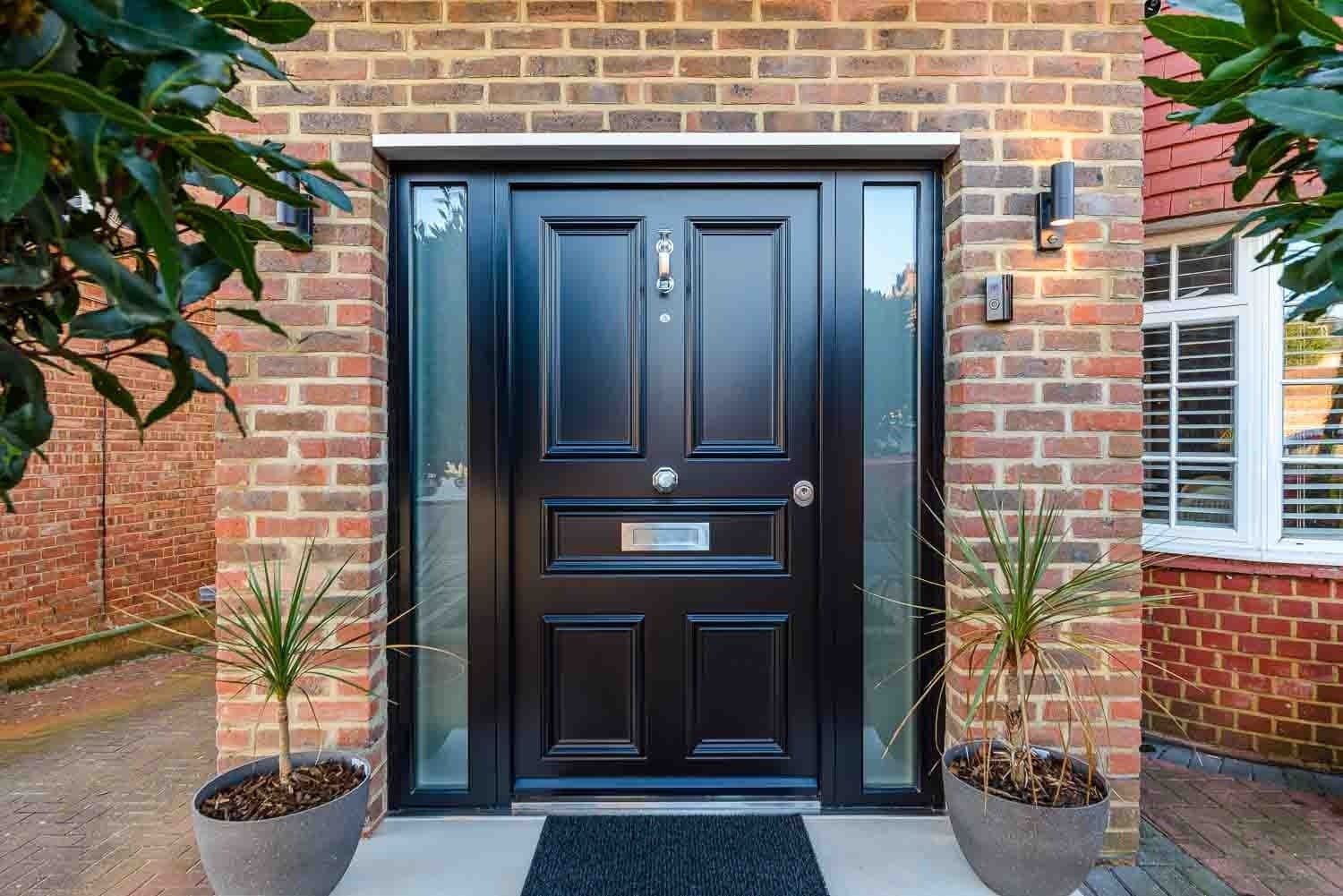 SteelR black panelled steel door with glass sidelights and palm plants